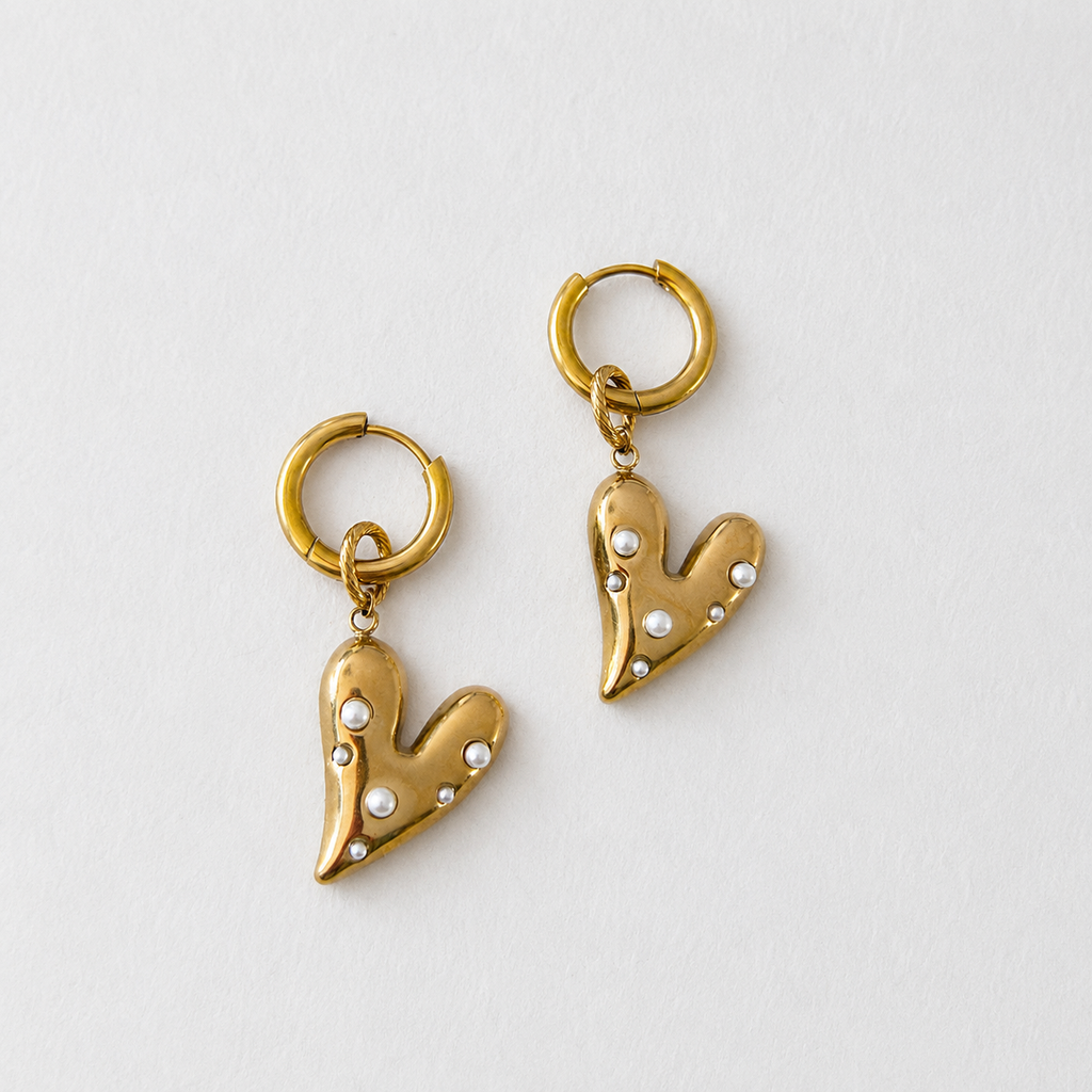 Handgemaakte statement oorbellen met gouden hart bezet met witte parels aan 12mm RVS ring