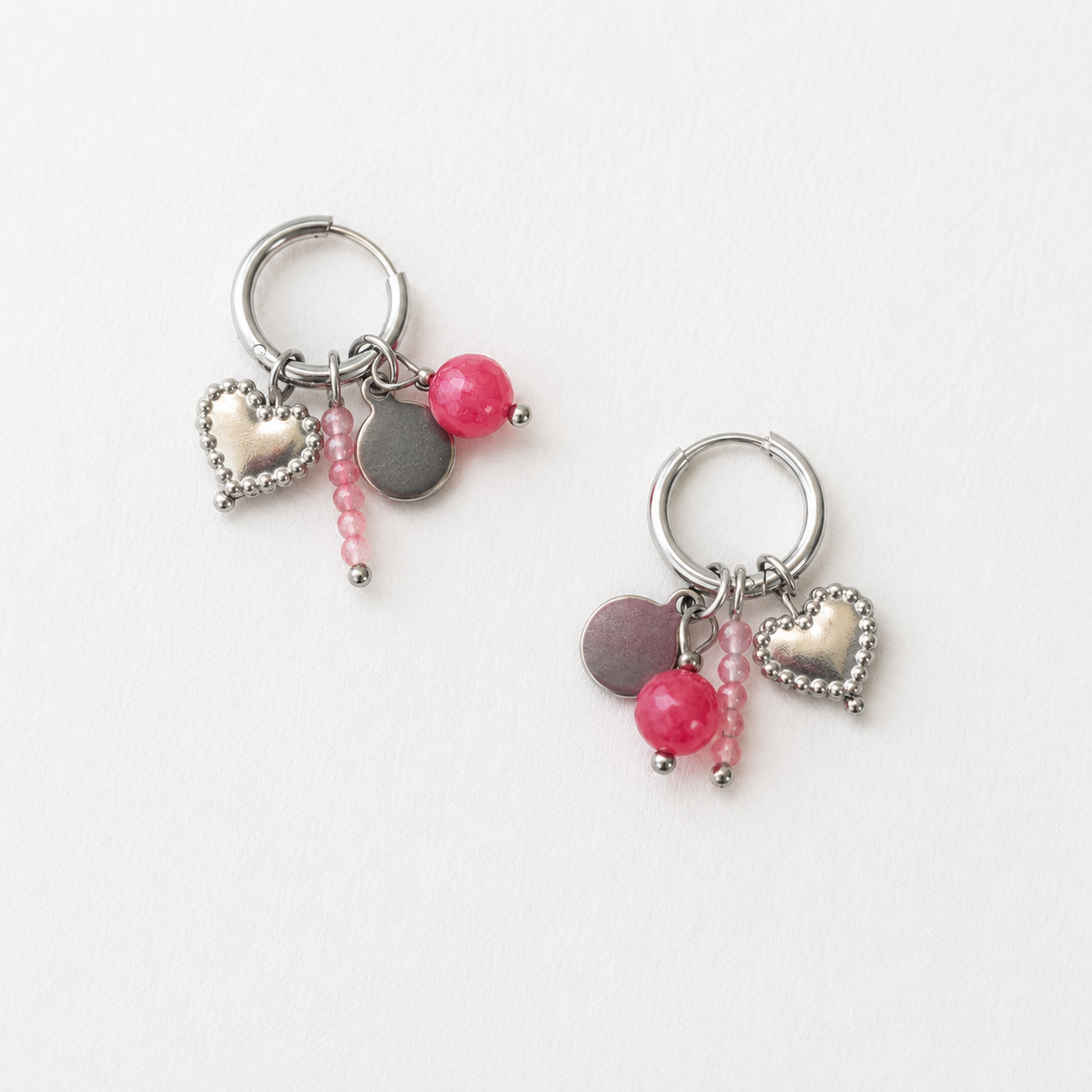 Handgemaakte zilver RVS oorringen met roze kralen, zilver hartje en een muntje. 