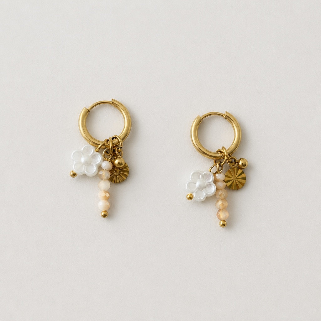 Handgemaakte gouden RVS oorbellen met transparante witte bloem, beige kristalkralen en gouden zon-muntje aan kleine gouden oorring